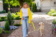 © mary_markevich - happy smiling woman in yellow sweater walking at her house with a dog golden retriever