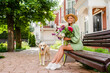 © mary_markevich - beautiful young woman in summer style outfit smiling happy walking with flowers and dog