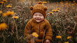 An overjoyed baby in a cute bear hat smiles wide while sitting amidst a field of wildflowers.
