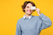 © ViDi Studio - Young smiling woman she wears grey knitted sweater shirt casual clothes hold in hand cover eye with mock up of credit bank card isolated on plain yellow background studio portrait. Lifestyle concept.