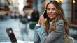 © imagineRbc - A multiracial woman is sitting at a table while engaged in a phone conversation through her cell phone