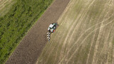 Fototapeta Miasta - Aerial view of a tractor preparing the field for planting.