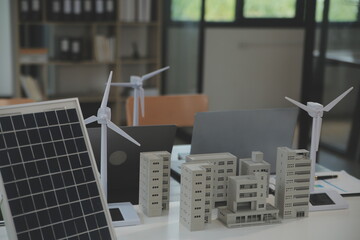 Wall Mural - Close-up at tablet, Engineers pointing at tablet with their hands. To jointly design the use of renewable energy with wind and solar energy. Concept of using renewable energy.