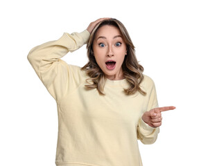 Wall Mural - Portrait of surprised woman pointing at something on white background