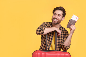 Canvas Print - Smiling man with passport, tickets and suitcase on yellow background. Space for text