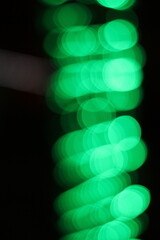 Blurry dreamy view of a blur of green lights.