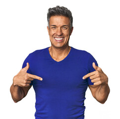 Middle-aged Latino man surprised pointing with finger, smiling broadly.