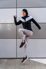 Wall Mural - Arab middle-eastern woman doing sport workout training outdoors in a urban area