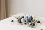 Fototapeta Tulipany - Stylish Easter eggs and spring flowers on rustic table. Happy Easter! Natural dye marble and blue eggs in tray and cherry blossoms. Happy Easter! Holiday minimal still life