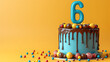 Birthday cake on a 6 years decorated with colorful sweets, chocolate, topper number six on a yellow background. Copy space.