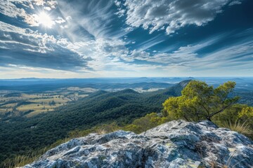 Wall Mural - view from the top of a high mountain peak overlooking an expansive landscape below