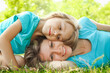 © Kostia - child with mother play outdoors in a park on the mother in the grass