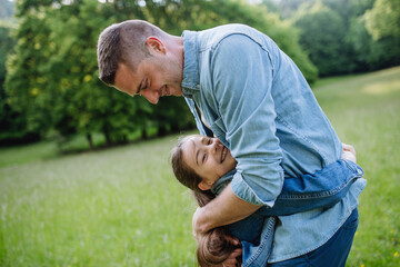 Wall Mural - Dad with daughter, playing at meadow, hugging, having fun. Concept of fathers's Day and fatherly love.