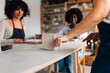 © Zamrznuti tonovi - Close up of tutor's hands cutting clay and preparing for pottery class