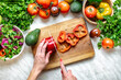 © kucherav - Healthy lifestyle concept. Female hands cut peppers for cooking a dietary summer salad at home in the kitchen, top view