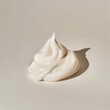 A dollop of thick, creamy white skincare cream on a muted white background