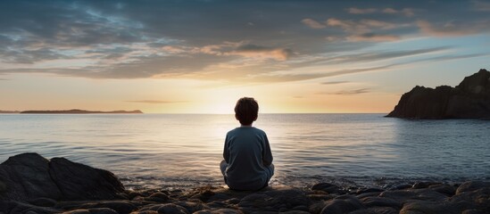 Poster - A person gazes at the liquid horizon as the sun sets, clouds painting the sky in hues of pink and orange. The beach is a tranquil landscape of peace and beauty