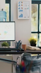 Poster - Vertical video Wheelchair in inclusive office for employees and displays showing marketing statistics. Medical chair in workspace offering accessibility to workers with disability and monitors with