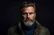 © Enrique - Portrait of a handsome mature man with long gray beard and mustache in a winter jacket. Men's beauty, fashion. Studio shot.