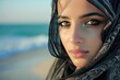 Beautiful arab saudi woman face posing on the beach with the sea in the background, copy space - generative ai