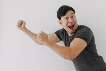 Happy and cheering funny face Asian man in black t-shirt isolated on white background.