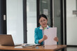 © Parichat - Female financial advisor or accountant  reviews her documents and using laptop.
