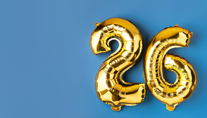Wall Mural - Banner with number 26 golden balloon with copy space. twenty-six years anniversary celebration concept on a blue background.