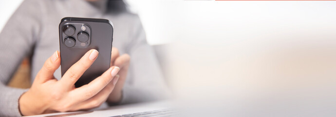 woman hand smart phone with computer on office