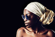 Black woman, sunglasses and scarf with fashion for style on a dark studio background. Face of young African female person, profile or model with headwear and eyewear for stylish accessories on mockup