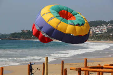 Parasailing, Parascending or Parakiting is an aquatic activity where a person attached to a parachute is towed by a boat at speed, causing them to rise above the water