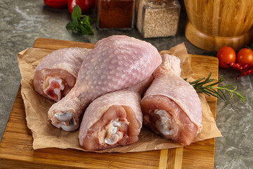 Raw uncooked chicken drumsticks over board