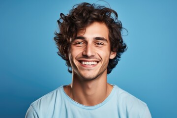 Wall Mural - A man with curly hair smiling at the camera. Suitable for various commercial and advertising purposes