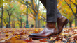 Man in classic boots performs elegance in motion through autumn leaves. Gentleman wearing brown leather shoes with sharp toes closeup