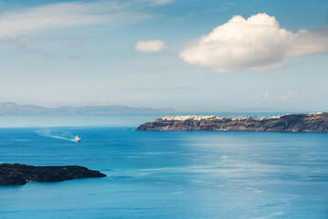 Wall Mural - Santorini island, Greece. Blue sea and the blue sky with white clouds