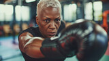 Fototapeta  - Afroamerican senior fit looking woman boxing in the gym