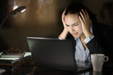 Fototapeta Pomosty - Worried tele worker in the night checking laptop