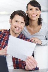 Wall Mural - photo of a happy couple doing finances at home