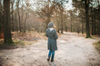 © ByAmerica - Woman walking in the forest on a cold autumn day