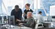 © Gorodenkoff - Diverse Colleagues Talking In Front Of Desktop Computer In Corporate Office With Megapolis Window View. Caucasian Male Developer Showing New Code To African CEO And His Female Assistant With Tablet.