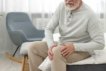 Wall Mural - Arthritis symptoms. Man suffering from pain in knee at home