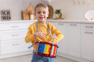 Wall Mural - Little boy playing toy drum in kitchen