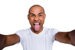 Close up photo healthy masculine dark skin he him his macho bald head funny arms telephone make take selfies tongue out of mouth cheerful wearing white t-shirt outfit clothes isolated grey background