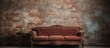 An antique sofa is placed in front of a brick wall, creating a unique and vintage aesthetic. The contrast between the classical furniture and the rough texture of the bricks adds character to the