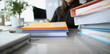 © H_Ko - Woman sitting at table with many yellow envelopes and folders closeup. Paper work concept