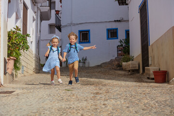 Wall Mural - Excited travelers run in the old streets of Peniscola, Spain