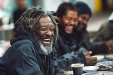 Joyful Black Homeless Man Laughs With Friends Group At Dinner In Soup House. African American Senior Tramp Eats Tasty Free Food Visiting Shelter