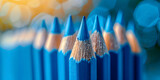 A row of different blue crayons on blue background abstract colors,
