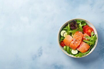 Wall Mural - Salted salmon salad with fresh green lettuce,cucumbers.Lunch bowl on a ketogenic,keto or paleo diet.Top view with lemon elements next to it on a light blue background with space for text 