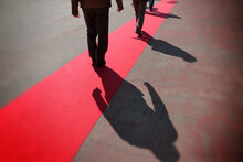 Perspective View Of Walking Onward People On Red Carpet Close Back View On Legs