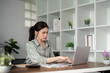 © Natee Meepian - Businesswoman using laptop computer work from home in room. freelance, green room area, lifestyle concept